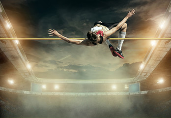 Naklejka na ściany i meble Athlete in action of high jump.