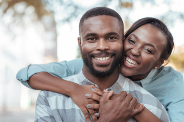 Affectionate young African couple standing outside on a sunny day - Powered by Adobe