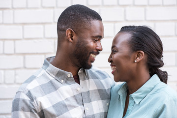 Content African couple smiling at each other in the city