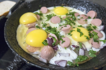cooking fried eggs with sausages
