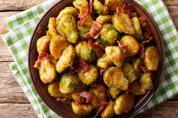 roasted brussels sprouts in breadcrumbs with crispy bacon close-up on plate. horizontal top view