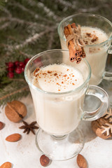 Eggnog, winter Christmas traditional hot drink with milk, eggs, rum. Christmass New Year decoration with gingerbread cookies.