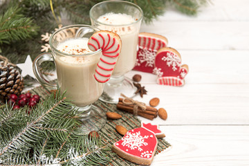 Eggnog, winter Christmas traditional hot drink with milk, eggs, rum. Christmass New Year decoration with gingerbread cookies.