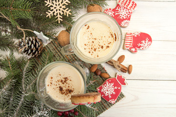 Eggnog, winter Christmas traditional hot drink with milk, eggs, rum. Christmass New Year decoration with gingerbread cookies.