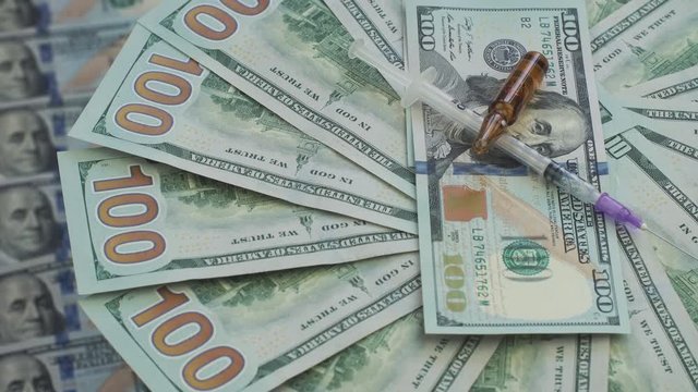 Paper money rotation. Drugs and pills for addiction lie on the thousands of paper dollars