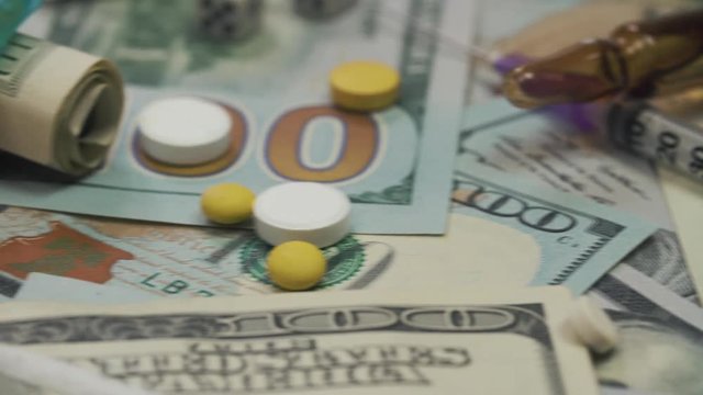 Pills, drugs, cocaine, syringe on dollar bank notes.