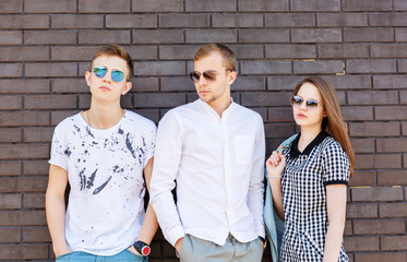 Beautiful young people standing against  brick wall