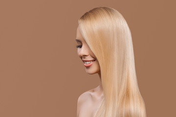 side view of beautiful girl with blonde long hair and closed eyes isolated on beige