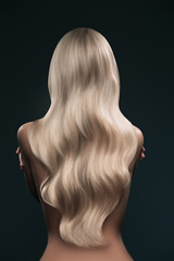 back view of girl with beautiful long blonde hair isolated on black