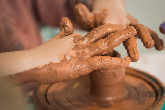 Boy playing with clay making a jar