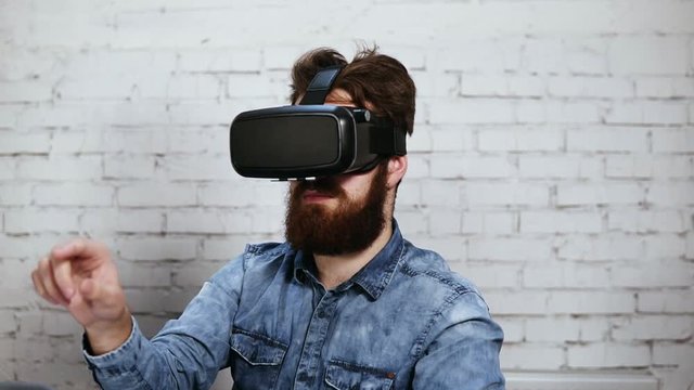 Man wearing virtual reality goggles in the office. He is working using virtual reality. Modern technology at work