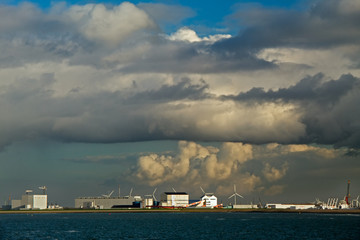 Fototapeta premium Coastline of the Dutch city Harlingen: windmills and factories under big clouds
