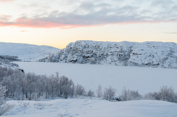 Trees covered with frost,the hills in the snow frozen lake .