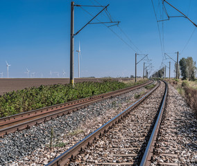 Obraz premium By rail train along wind power plant.