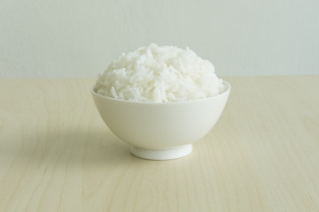 STEAMED RICE SERVED ON WOOD TABLE
Steamed rice in a white bowl are served on a wood table. 