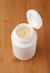 White plastic medical bottle whit medicine granules