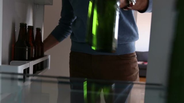 Man taking beer from refrigerator