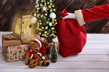 Obraz premium santa claus putting secretly gift sack under the christmas tree