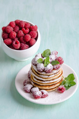 Pancakes with raspberries on blue table