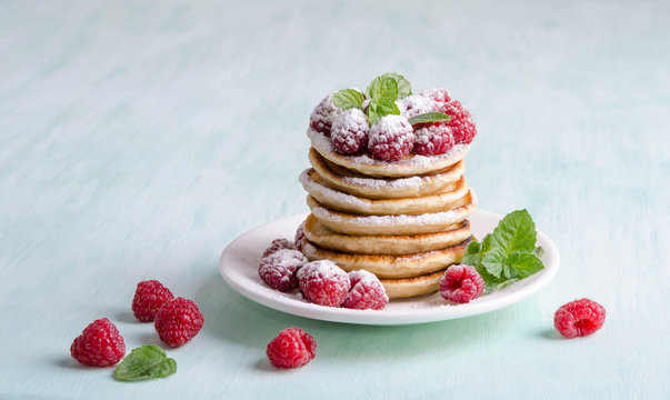 Pancakes with raspberries on blue table
