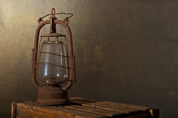 Old Rusty Lantern on the Wooden Desk in the Attic