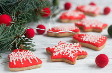 Naklejka premium Gingerbread bells, stars, garland of felted beads and fir branches on a light background Christmas or New Year's card.