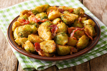 Crispy fried Brussels sprouts with bacon close-up on a plate. horizontal