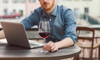 Hipster having a glass of wine at the bar