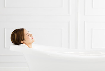 Obraz na płótnie Canvas young Beautiful woman relaxing in bathtub