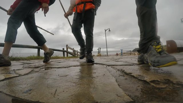 Father, mother and little son walking togeather by the famous Camino de Santiago or "The Way of Saint James" during the rainy day.