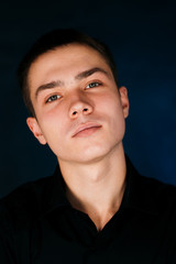 young guy on a dark studio background