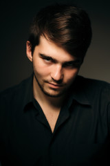 Fototapeta premium young brunette guy on a dark background