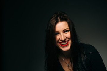 Fototapeta premium emotional girl smiling on a dark background