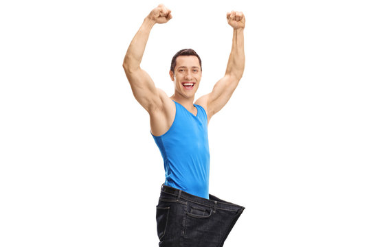 Overjoyed muscular guy wearing a pair of oversized jeans