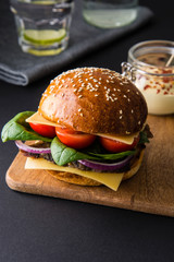 Burgers with meat, tomatoes, cheese and spinach.
