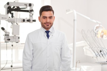 Naklejka na ściany i meble Portrait of a handome male dentist posing at his office copyspace medicine healthcare professionalism occupation uniform dentistry practitioner experience concept.
