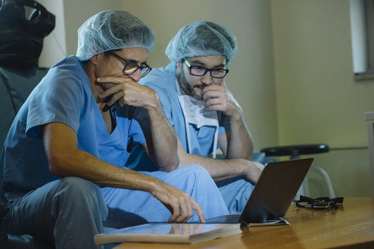 Doctors watching laptop pensively