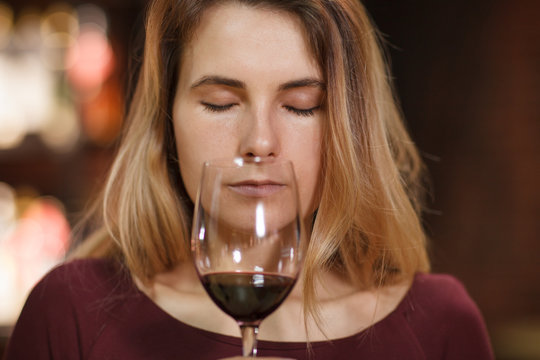 Attractive woman taste red wine in the restaurant