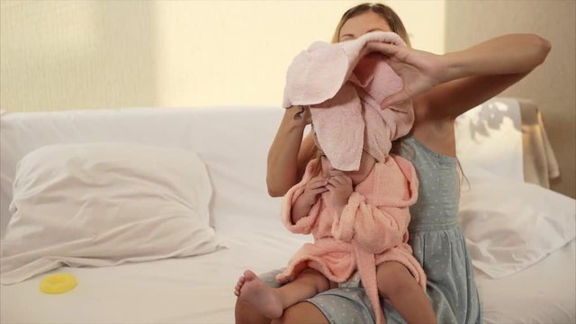 Mother wipes her baby's towel in the room. Caring for children.