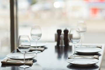 Glasses, fork, knife served for lunch in cafe with luxury interior
