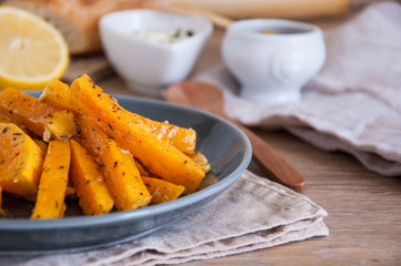 Snack. Pumpkin pieces baked in spices on a plate with cream sauce