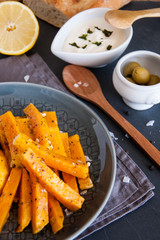 Snack. Pumpkin pieces baked in spices on a plate with cream sauce