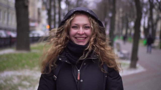 Young beautiful girl jumping in the park to keep warm