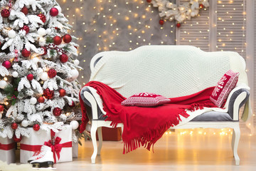 Gorgeous christmas tree in luxury interior with gifts in classic white and red colors. New year at...