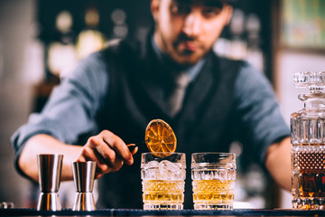 Portrait of barman adding ingredients and creating cocktail drinks on bar counter - obrazy, fototapety, plakaty