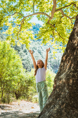 Little girl hugging big tree