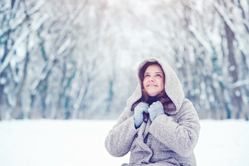 Fototapeta na wymiar Happy young woman outside in snow smiling joyful on snowing winter day.