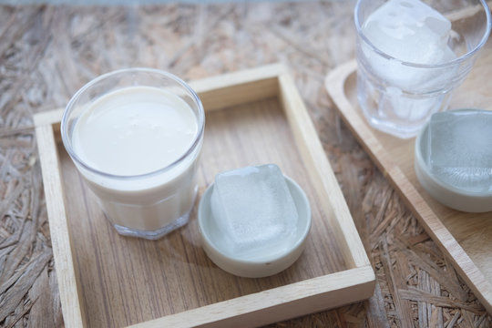 Glass of tasty fresh milk on wooden table