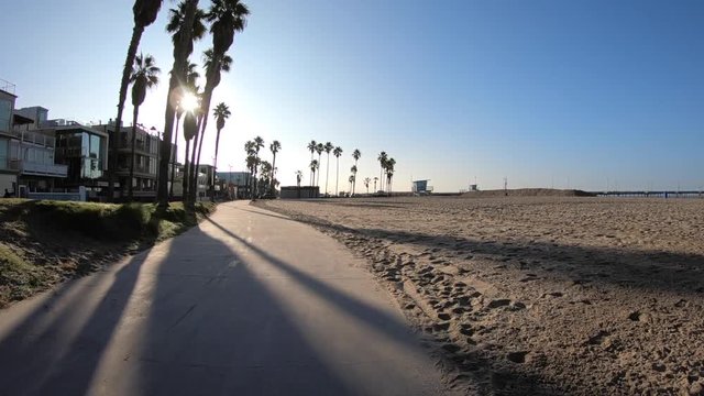 Slow motion moving shot on bike path near the Venice Beach pier in Los Angeles California.