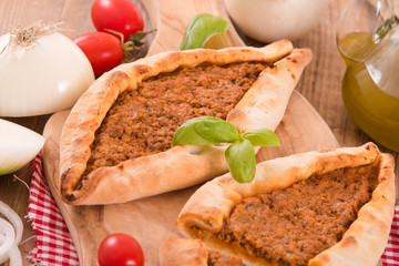 Turkish pide pizza with meat and onion.